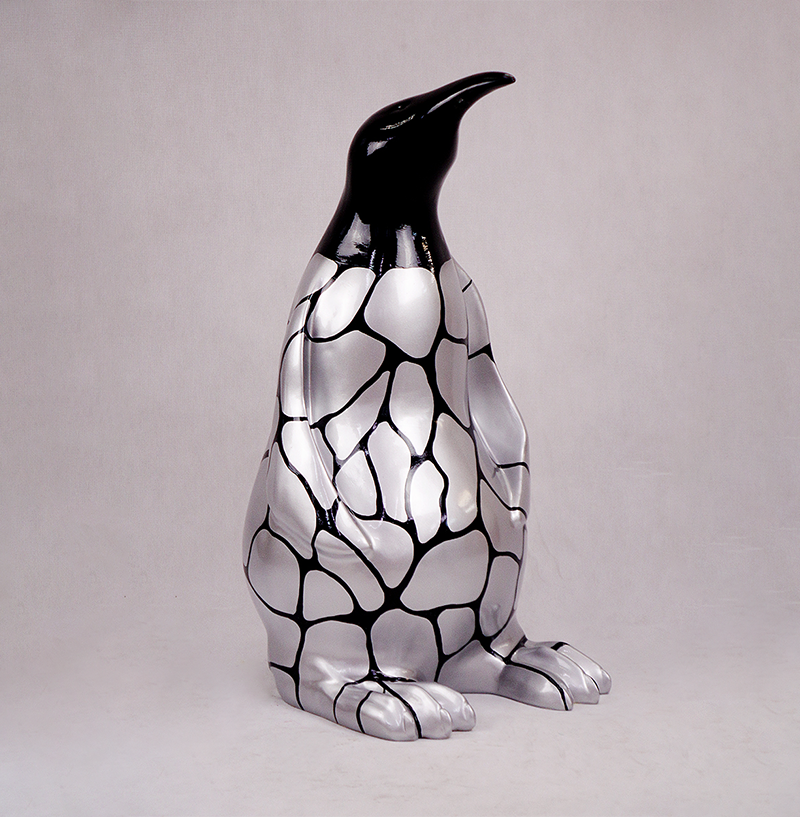 Penguin 100 cm - silver patches 1 Sculpture of a penguin with a shiny silver body and black geometric pattern.