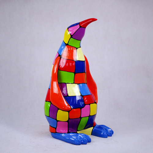 Colorful, patchwork-painted penguin statue with vibrant red, green, blue, yellow, and purple sections.