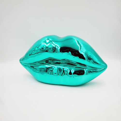 Metallic turquoise sculpture of lips against a plain white background.