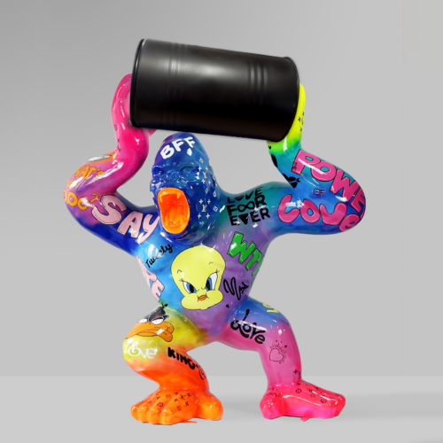 Colorful sculpture of an abstract gorilla holding a black barrel, decorated with various graffiti-like illustrations and text including 