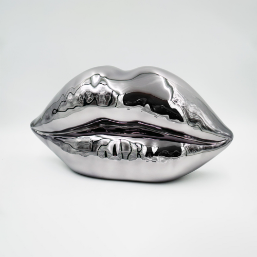 Sculpture of metallic lips against a plain background.