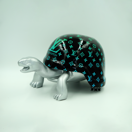 Silver turtle figurine with a black shell featuring turquoise Louis Vuitton logos.