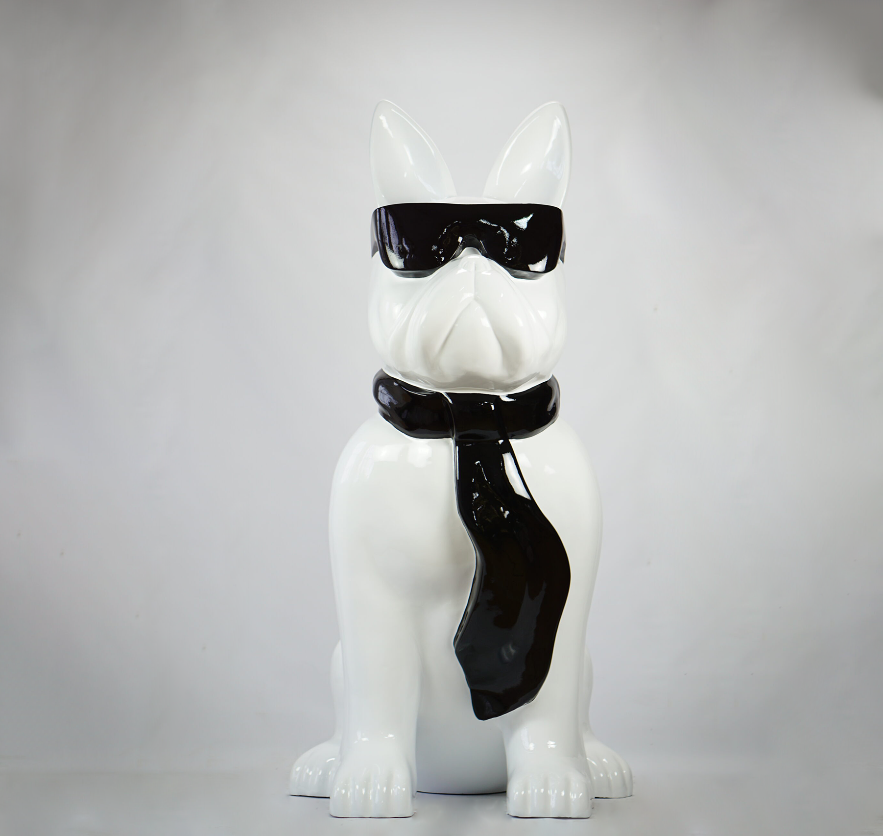Large bulldog figure with tie and glasses - black and white 2 Ceramic sculpture of a dog wearing sunglasses and a tie.