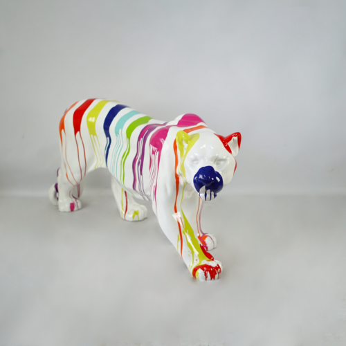 A white ceramic bear sculpture with multi-colored paint drips in rainbow colors.