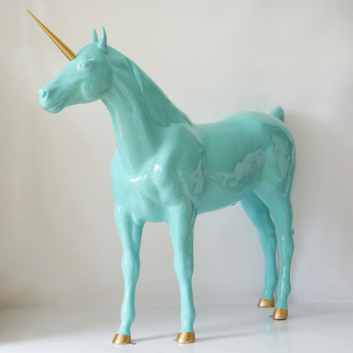 A glossy turquoise unicorn statue with a golden horn and hooves.