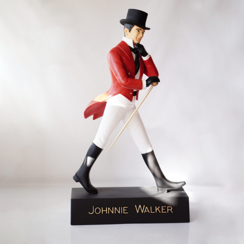 Johnnie Walker statue of a man in a red coat, white pants, black boots, and a top hat walking with a cane.