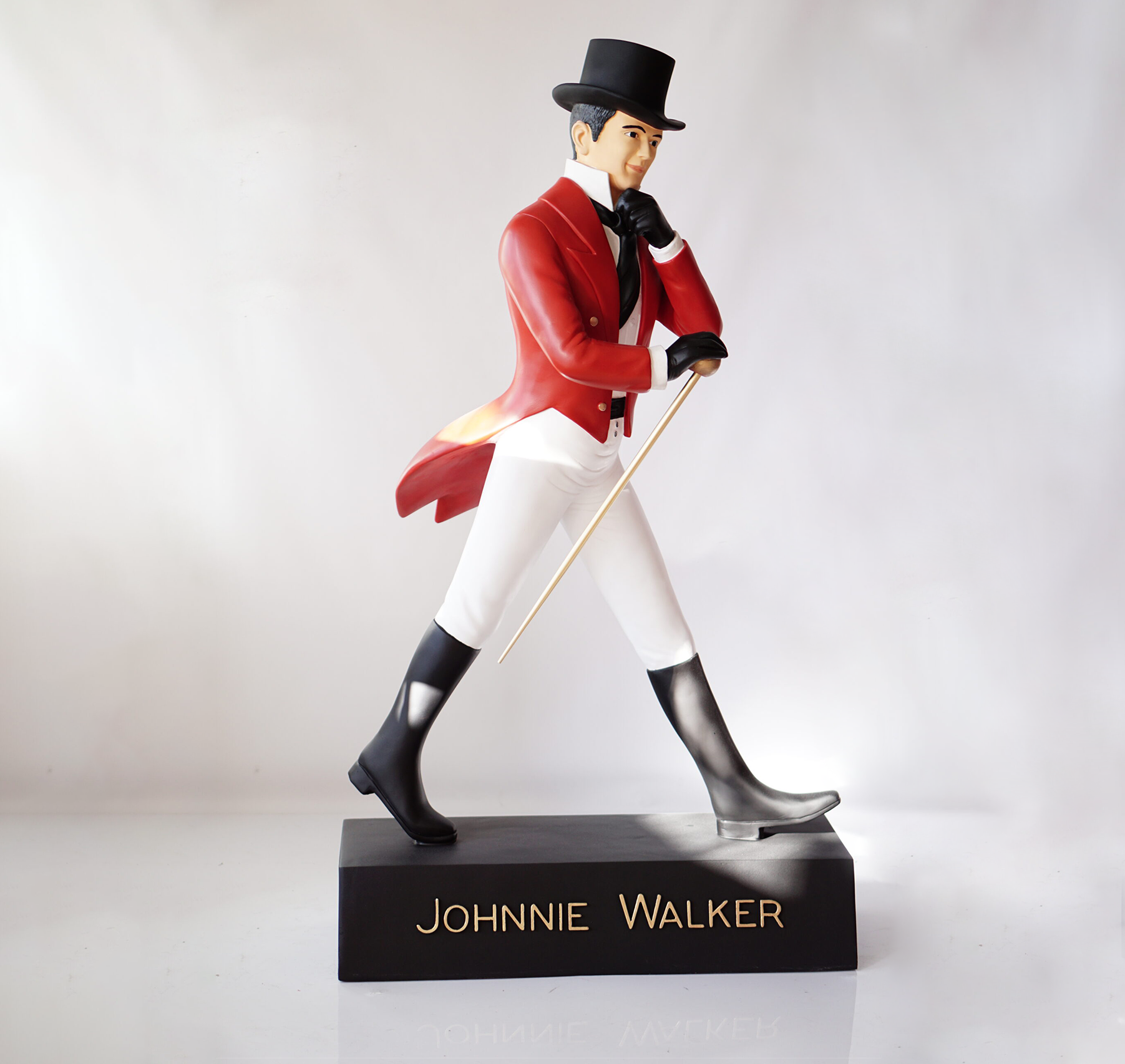 Johnnie Walker - red label 2 Johnnie Walker statue of a man in a red coat, white pants, black boots, and a top hat walking with a cane.