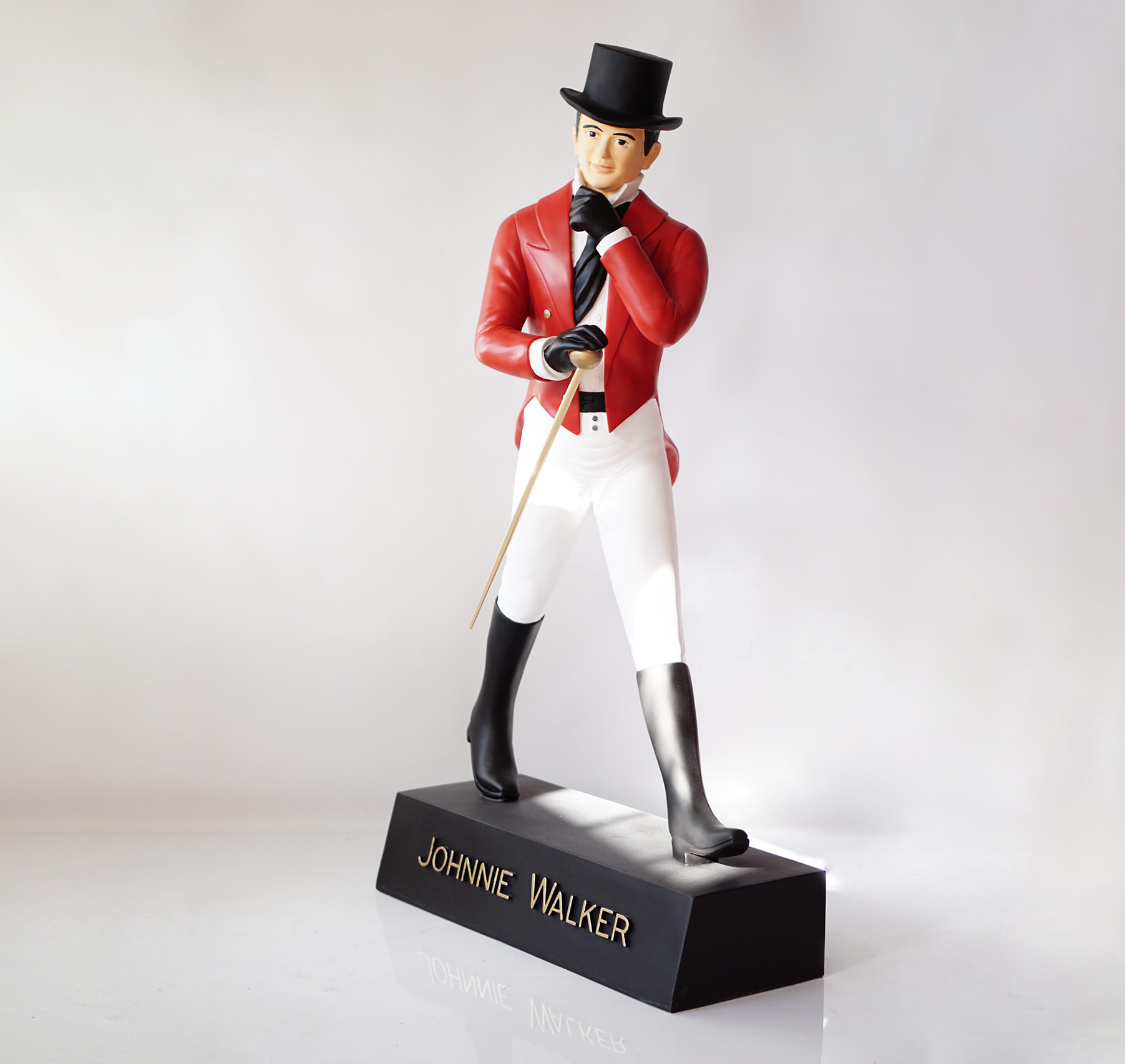 Johnnie Walker - red label 1 A statue of a figure in a top hat, red coat, white pants, and black boots, labeled