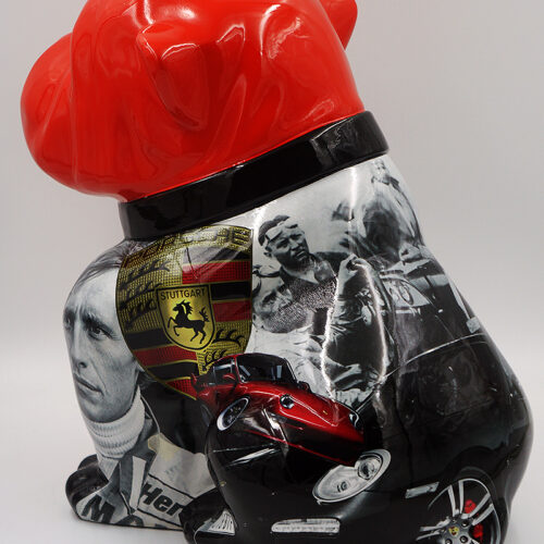 Sculpture of a dog with a glossy red head and black-and-white body decorated with images of race cars, a Stuttgart emblem, and people.