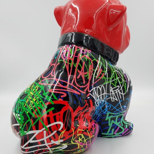 A colorful, graffiti-covered bulldog statue with a glossy red head and black body adorned with vibrant, multicolored scribbles and tags.