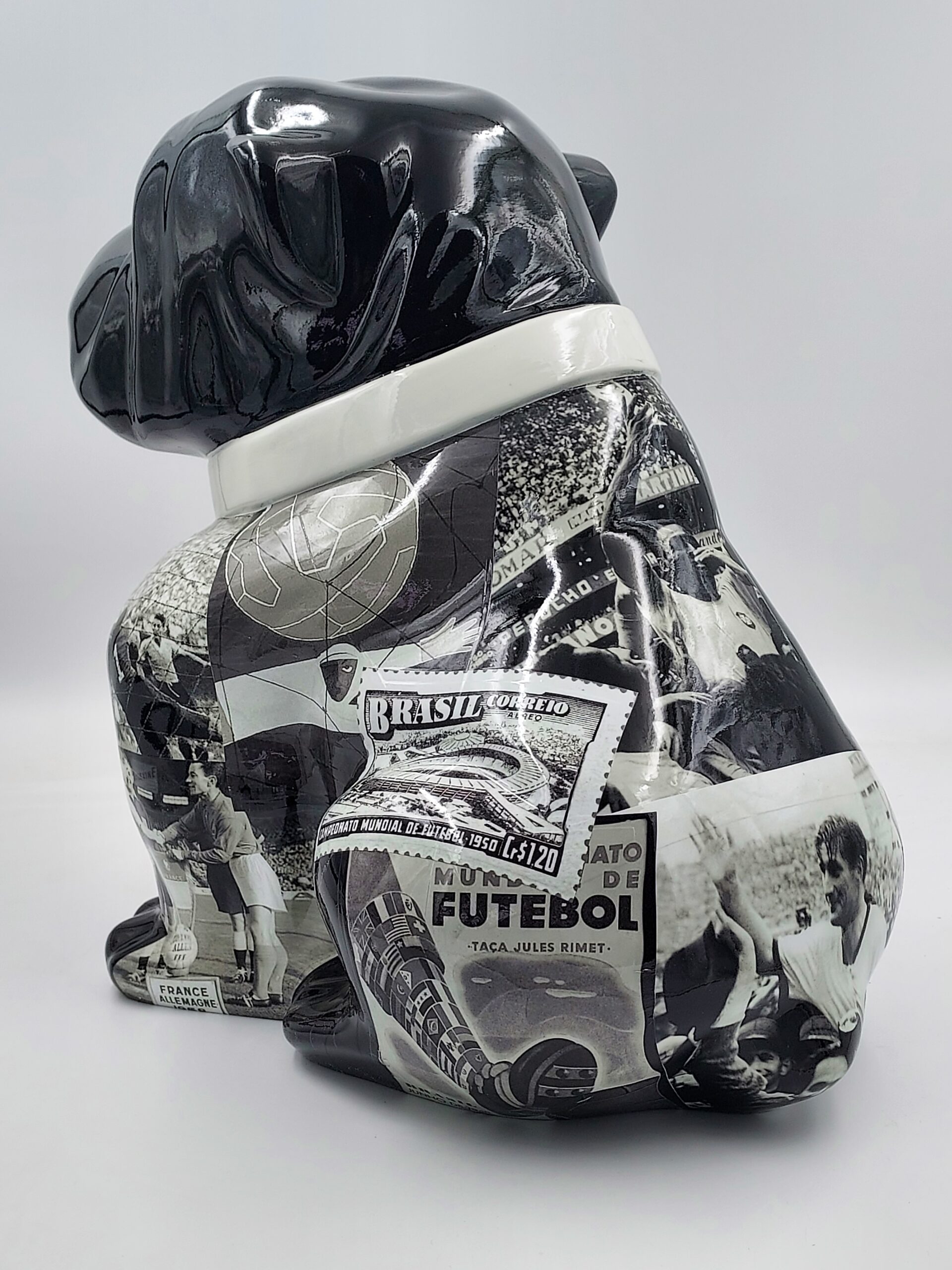 Bulldog Angelo 60cm dog - football 2 Black ceramic bulldog sculpture decorated with vintage soccer-related images and memorabilia in grayscale.
