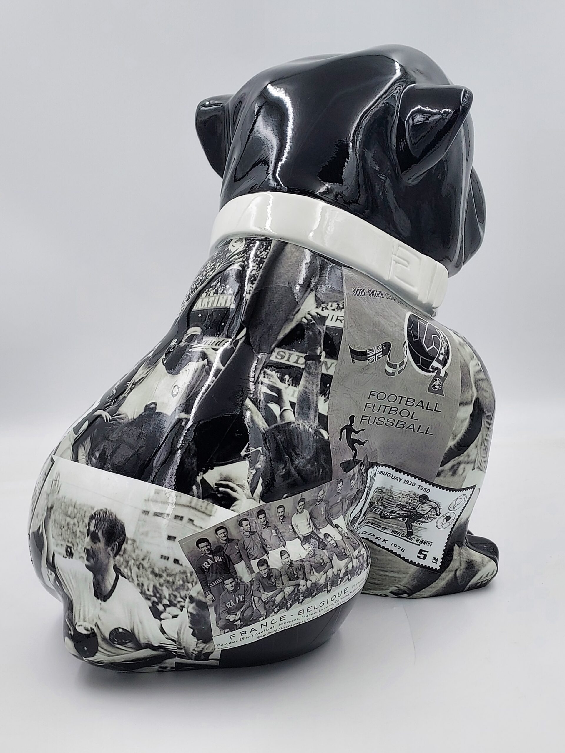 Bulldog Angelo 60cm dog - football 3 A black and white ceramic bulldog sculpture with collage images related to the history of football covering its body.