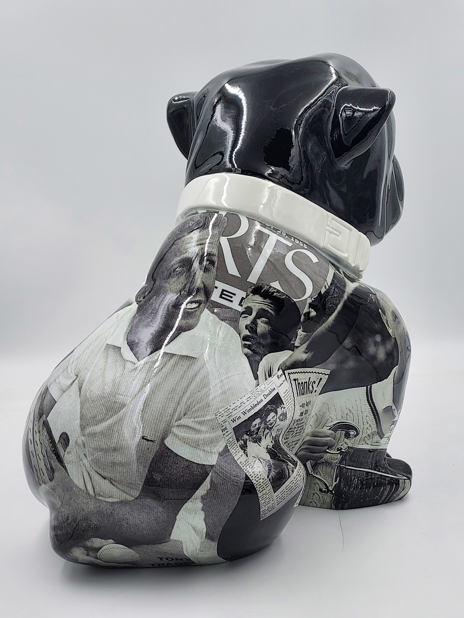 Bulldog Angelo 60cm dog - Tennis 3 Black and white bulldog figurine with a collage of vintage sports newspaper clippings on its body.