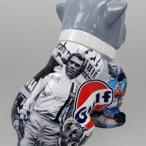 Figurine of a seated bulldog decorated with black-and-white images of a race car driver, featuring a prominent Gulf logo.