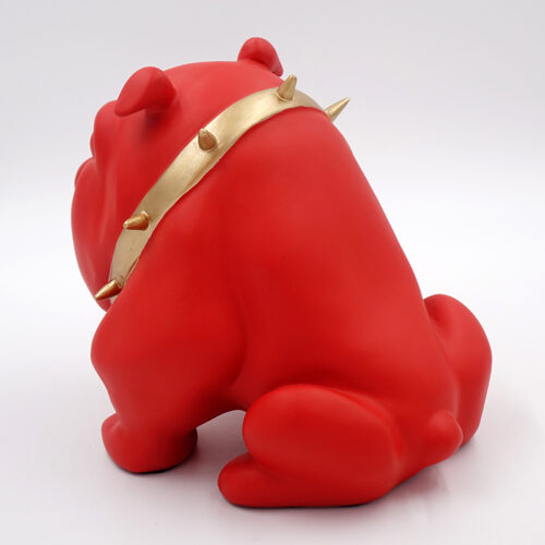 Red bulldog figurine with a gold spiked collar sitting on a white background.