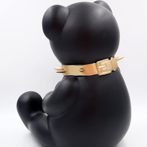 A black bear figurine with a gold spiked collar, shown from behind, against a white background.
