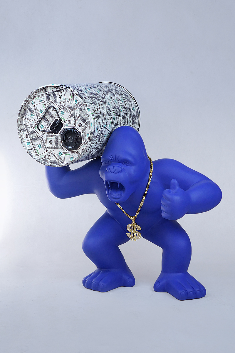Gorilla with a Barrel - OK 1 Blue gorilla statue with an open mouth, wearing a gold dollar sign necklace, posing with a large money-patterned barrel on its shoulder and giving a thumbs-up.