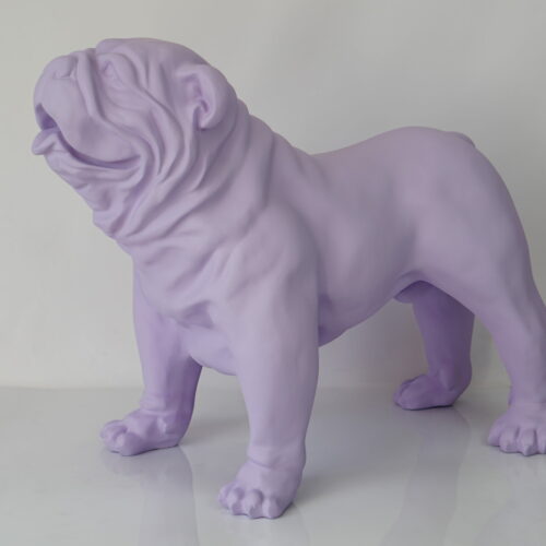 A lavender-colored bulldog statue standing on a reflective surface against a plain white background.