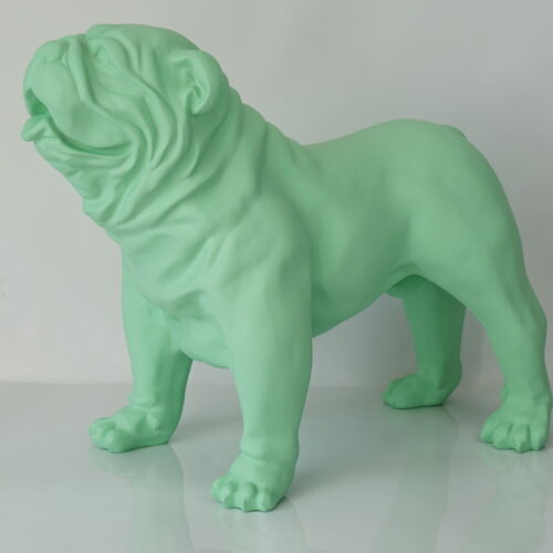 Green sculpture of a bulldog standing on a reflective surface.