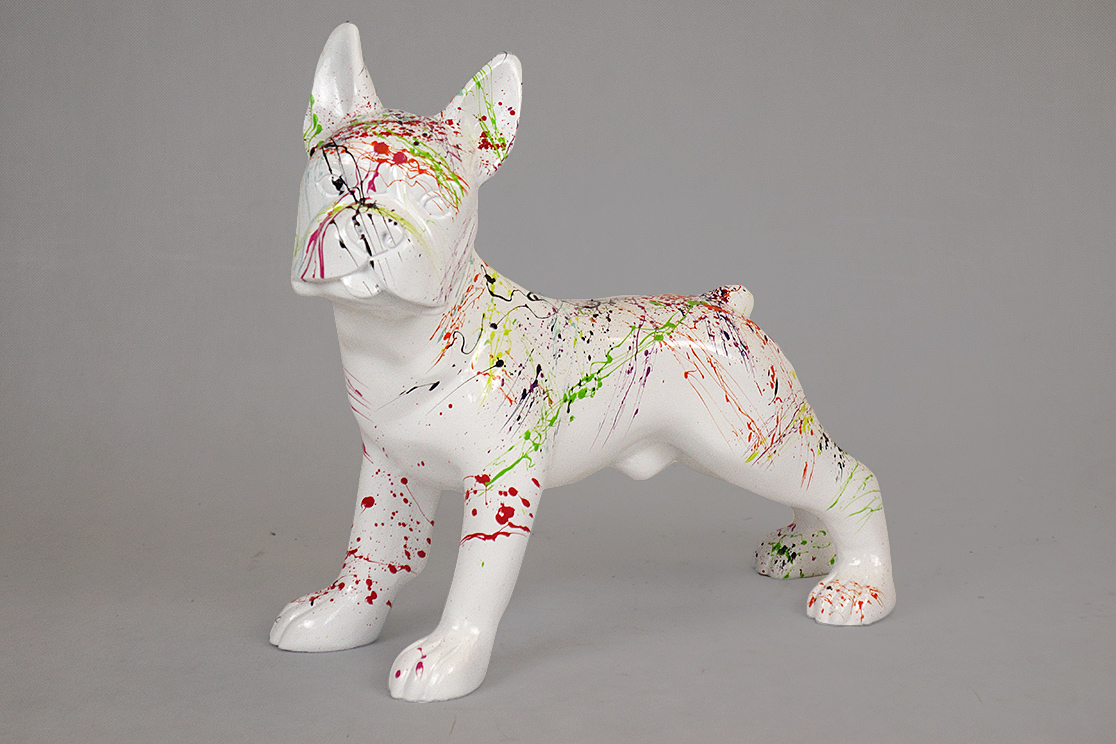 Bulldog Figi M - white splash 1 White dog statue with colorful paint splatters on its body and face.