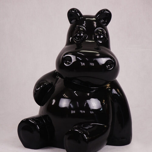 Glossy black sculpture of a cartoonish hippopotamus sitting down.