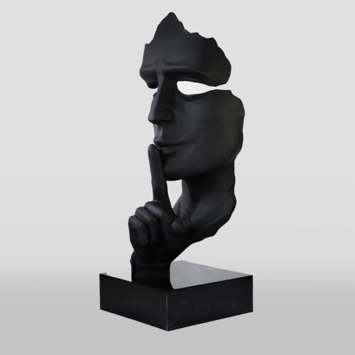 Black sculpture of a fragmented face holding a finger to its lips in a 