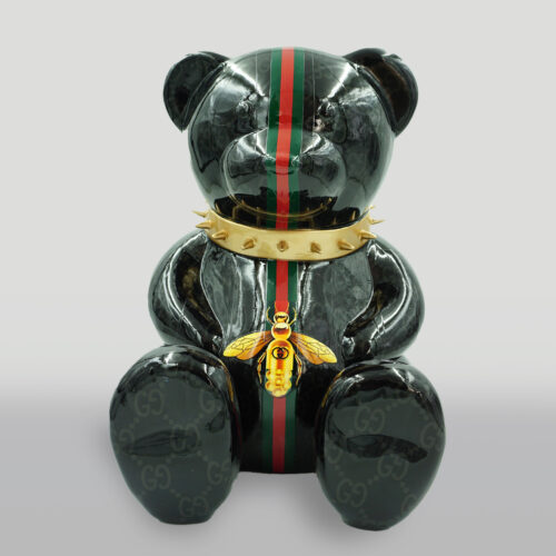 Black bear figurine with green and red stripes, a gold spiked collar, and a bee medallion.