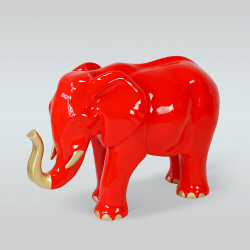 Red ceramic elephant with gold accents on its tusks and toenails.