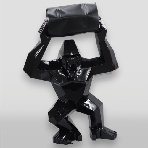 Black angular gorilla sculpture holding a barrel above its head.