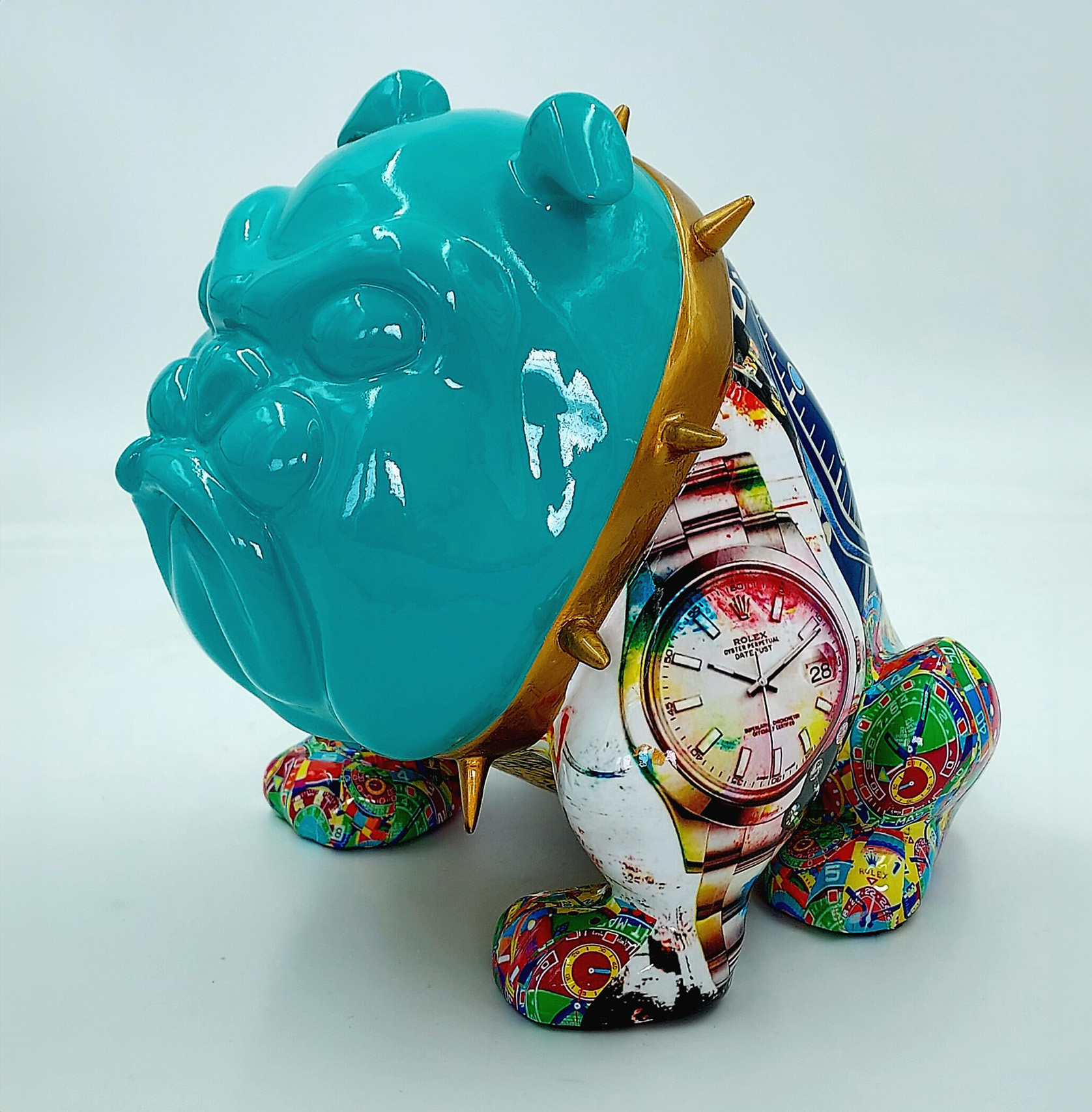 Bulldog Avella 55cm dog - Rolex 1 A sculpture of a stylized bulldog with a glossy teal head and colorful, patterned body featuring a watch design, wearing a gold spiked collar.