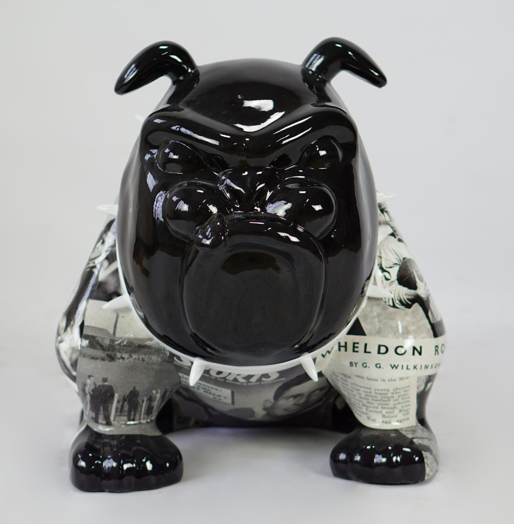Bulldog Avella Dog 55cm - rugby 1 Ceramic bulldog statue with a glossy black head and newspaper print on its body.