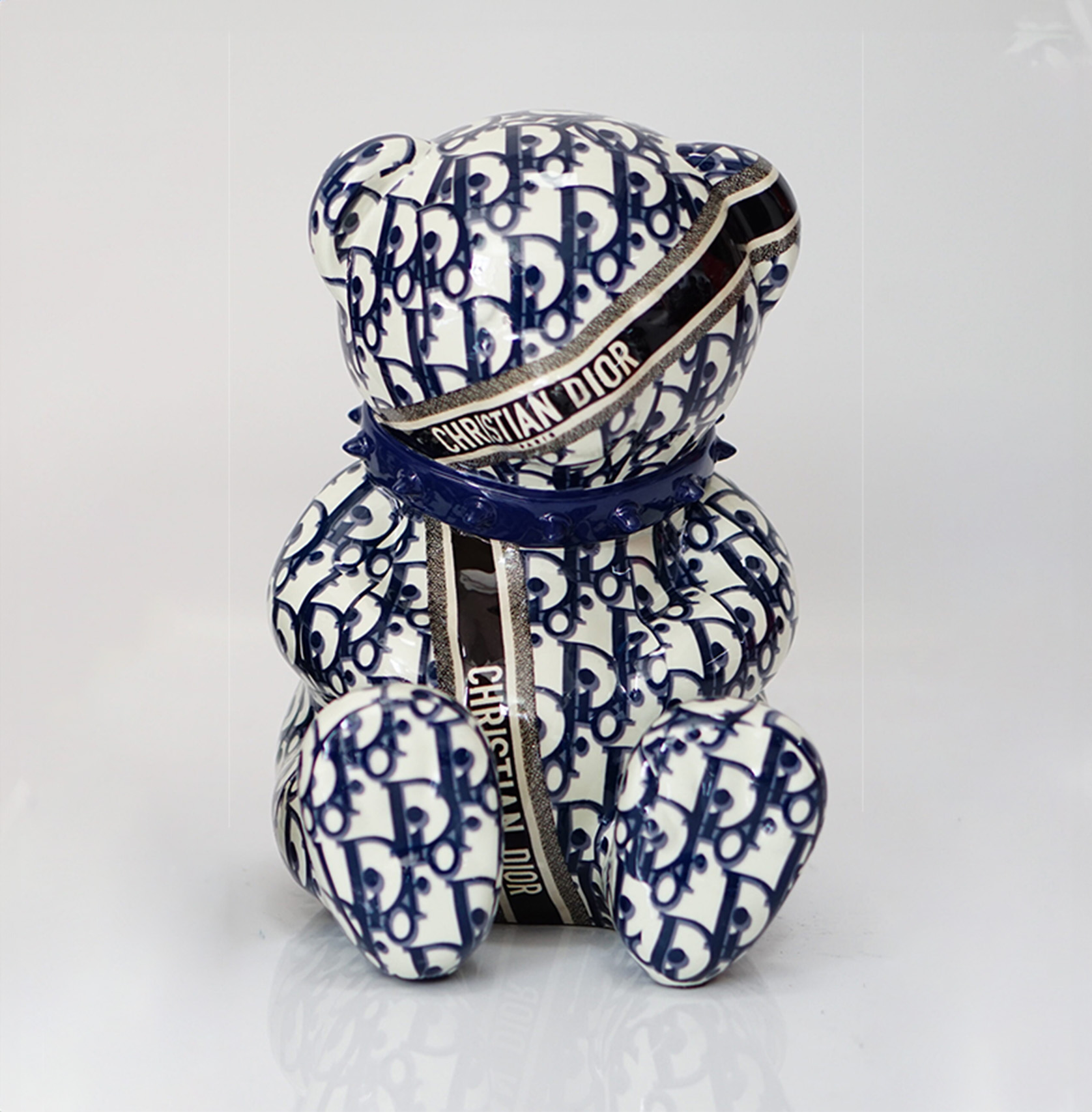 Bear CD H-31cm 1 A ceramic bear figurine with a blue and white pattern, featuring the text