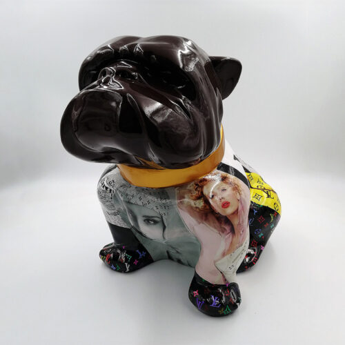 Statue of a bulldog with a shiny black head and a body covered in various printed images and colorful designs, wearing a gold collar.