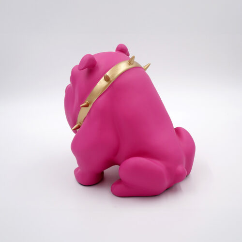Pink bulldog figurine with a gold spiked collar facing away.