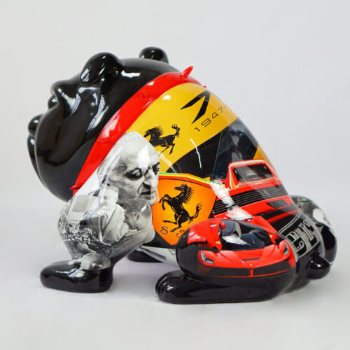 A black bear sculpture decorated with Ferrari-themed imagery including the Ferrari logo, a red Ferrari car, and black-and-white photographs of individuals.