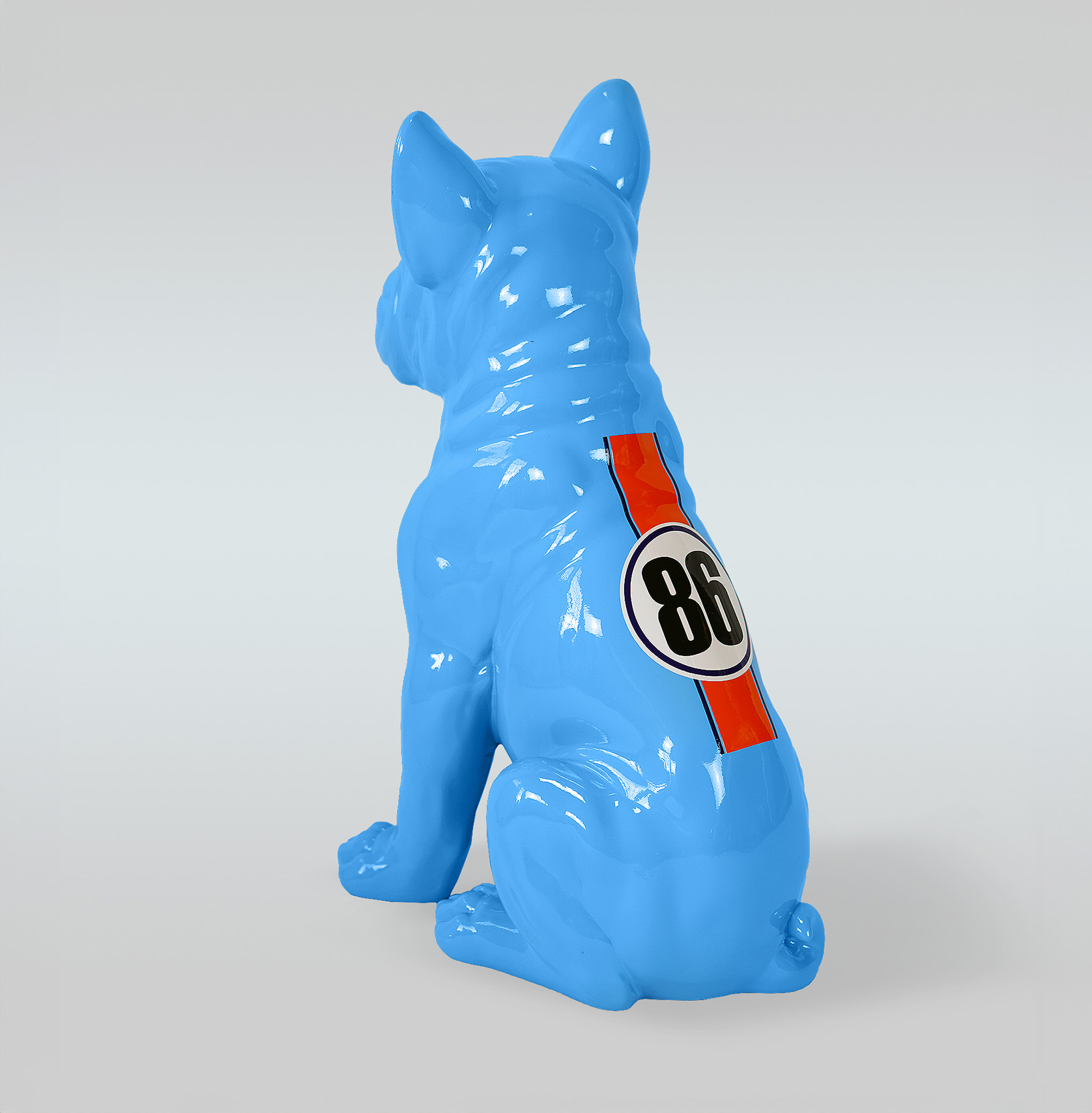 Bulldog Juki L Dog - Sitting One Color + Sticker 2 Niebieska ceramiczna figurka siedzącego buldoga z numerem 86 na plecach.