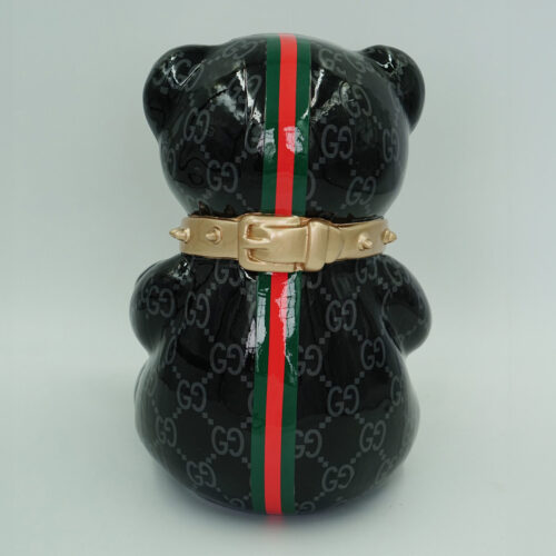 Black ceramic bear figurine with a red and green vertical stripe and a gold belt around its waist.
