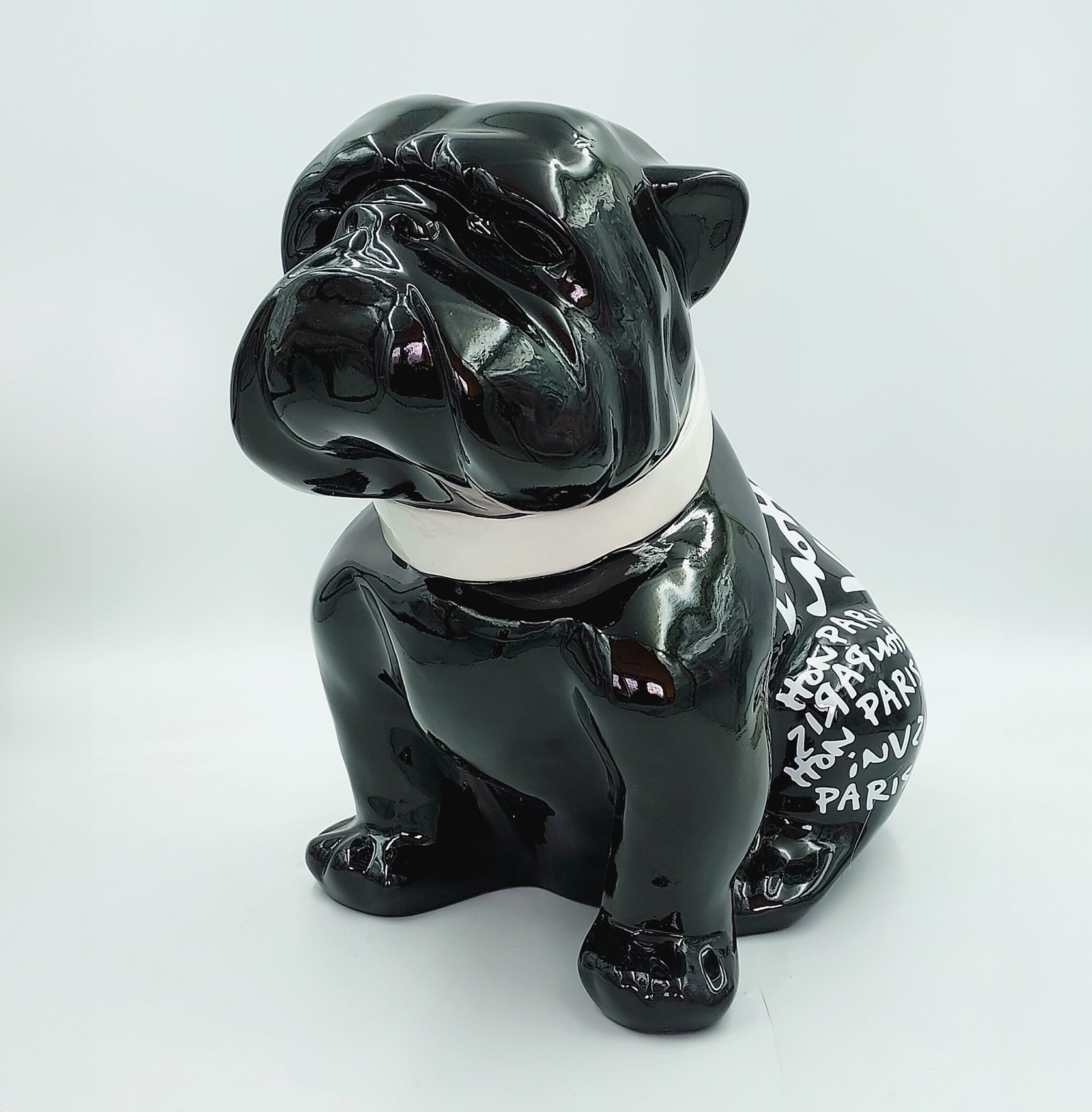 Bulldog Angelo 60cm dog - Louis Paris 1 Czarna ceramiczna figurka psa z białym obrożem i napisem na grzbiecie.