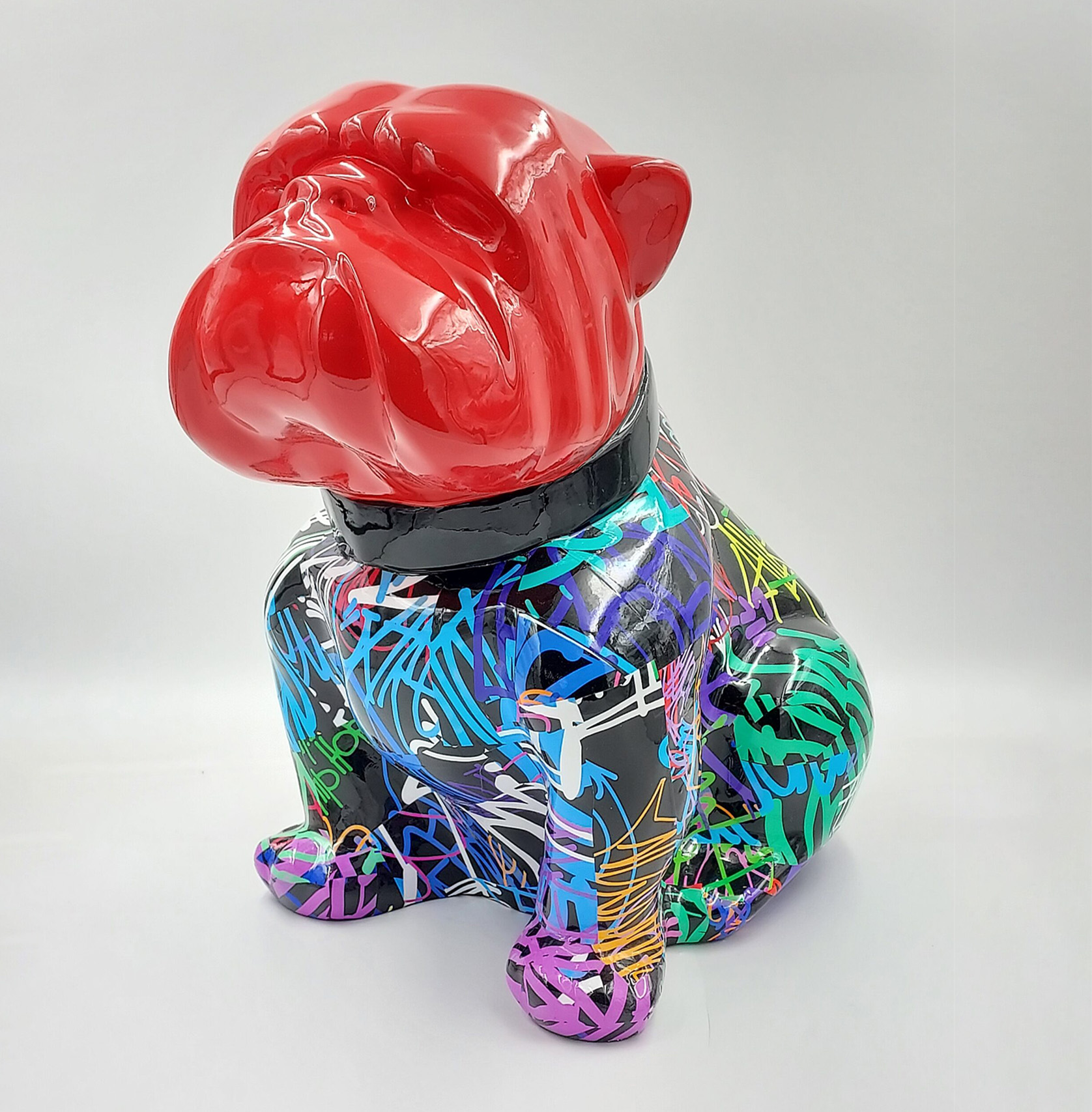 Bulldog Angelo 60cm dog - spray 1 Colorful bulldog statue with a red head and a body covered in multicolored graffiti-style patterns.