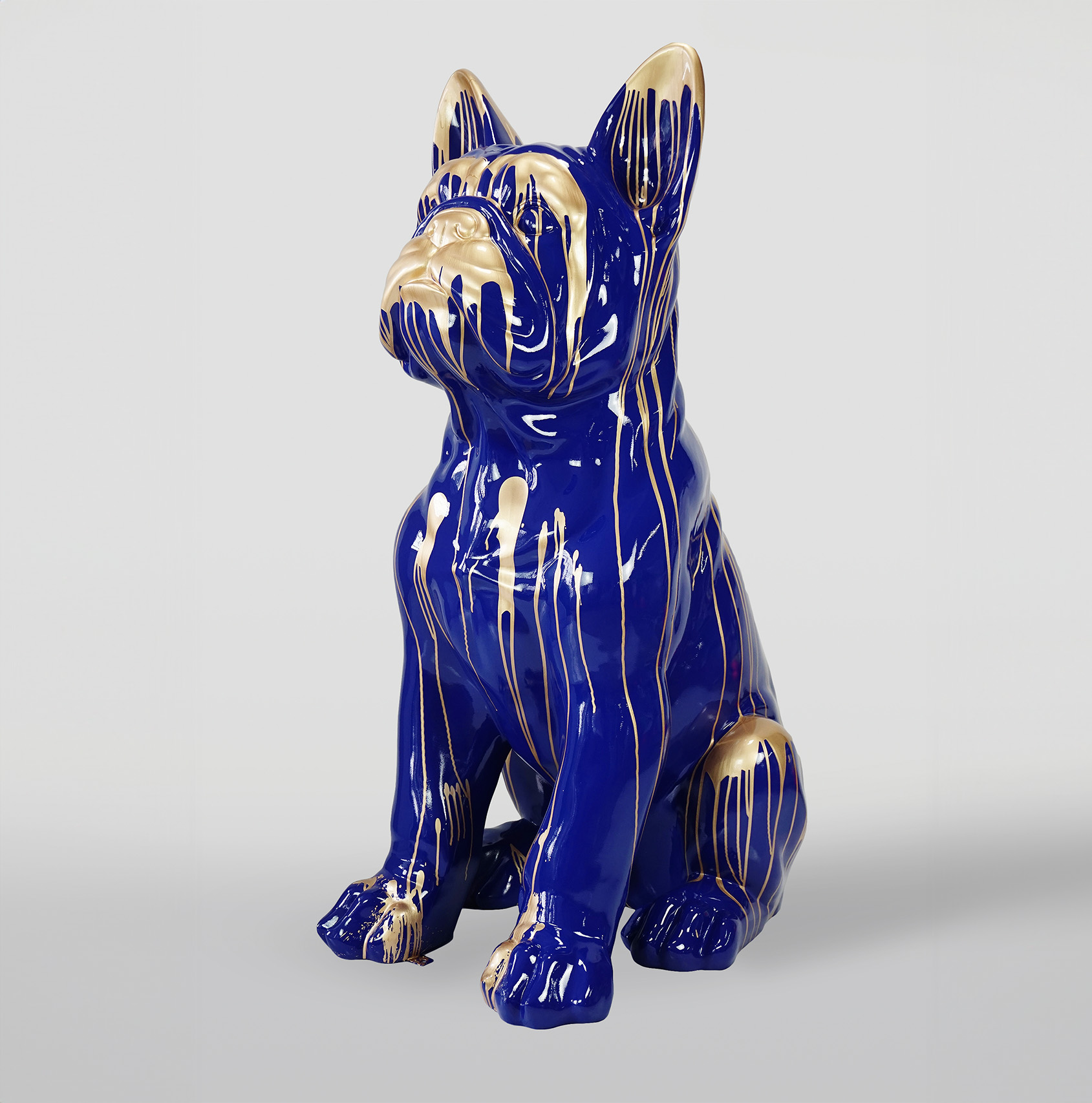 Large French Bulldog Figure Statue of a sitting dog with a glossy blue surface and gold paint dripping from the top.