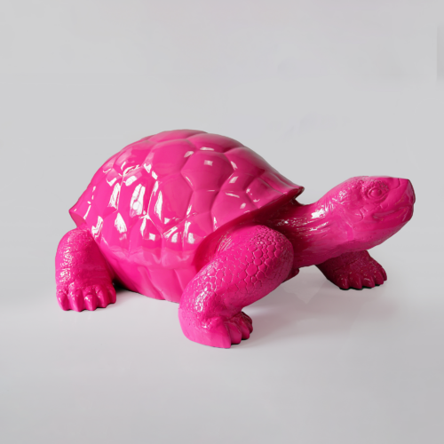 Pink turtle sculpture on a plain background.