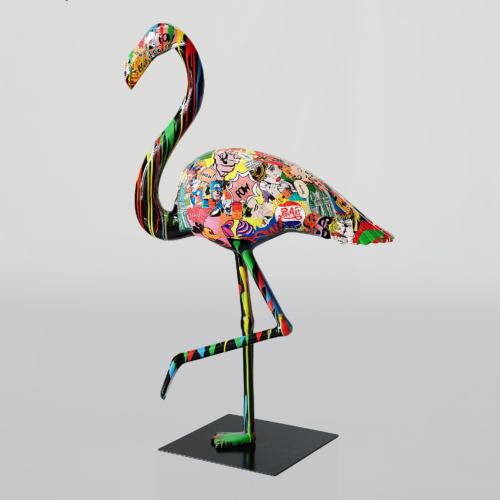 Colorful flamingo sculpture covered in various stickers and graffiti art, standing on one leg with a black base.