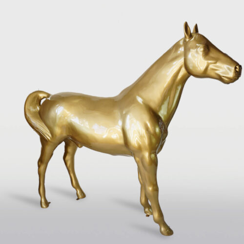 Gold metallic horse sculpture on a plain background.