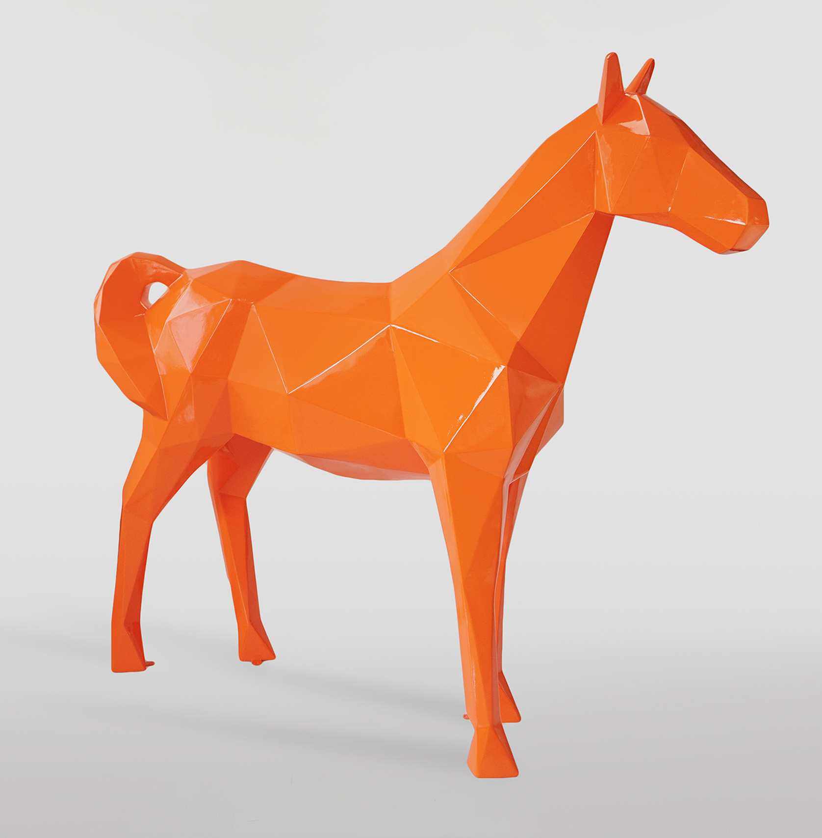 Large geometric horse made of laminate - orange 1 Orange polygonal horse sculpture with a glossy finish on a white background.