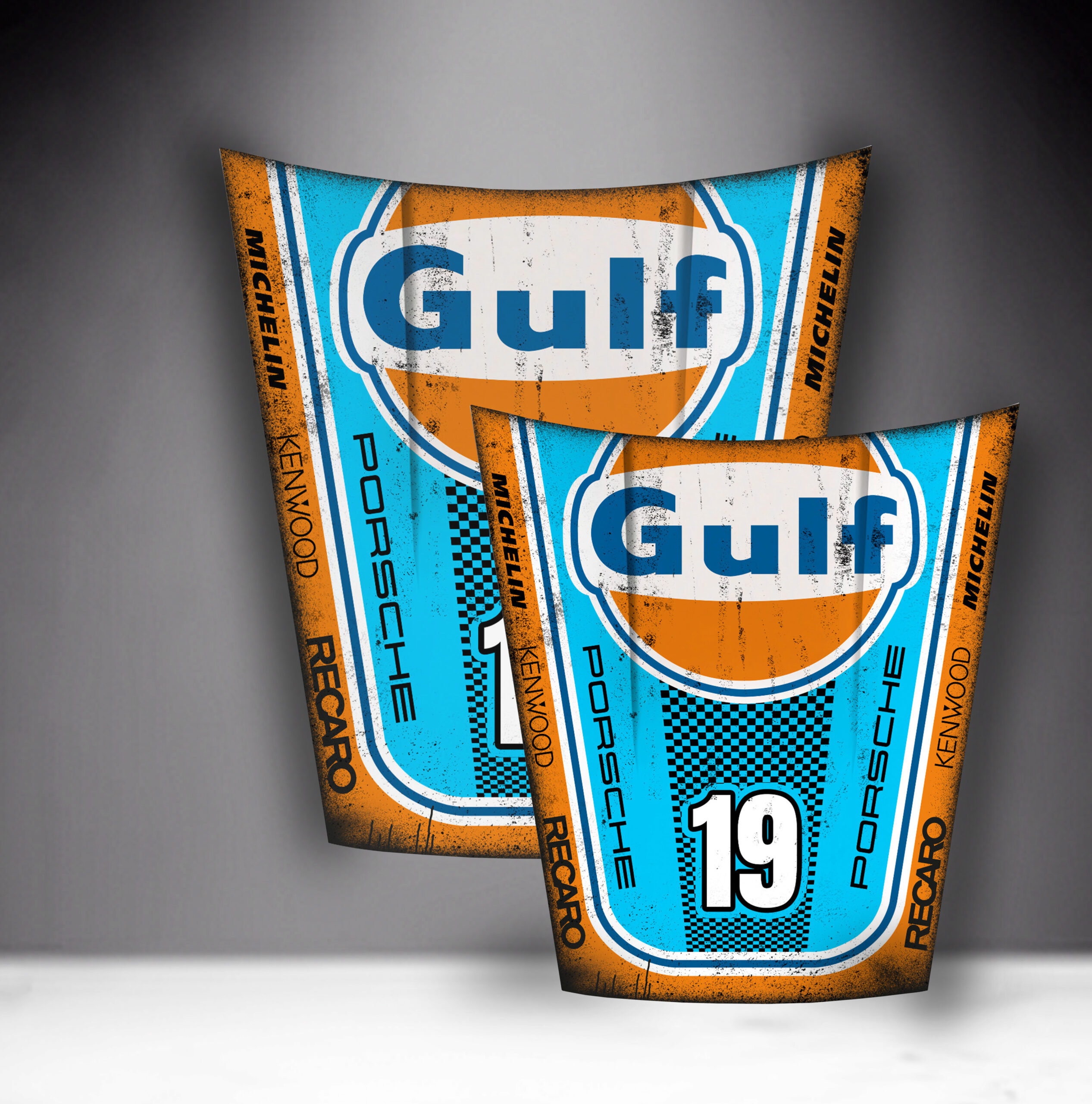 Car Mask 911 - Theme 16 1 Two vintage-style Gulf Porsche racing car hoods with blue and orange designs, displaying the Gulf logo, the number 19 on one and 14 on the other, and sponsor names Michelin, Kenwood, and Recaro.
