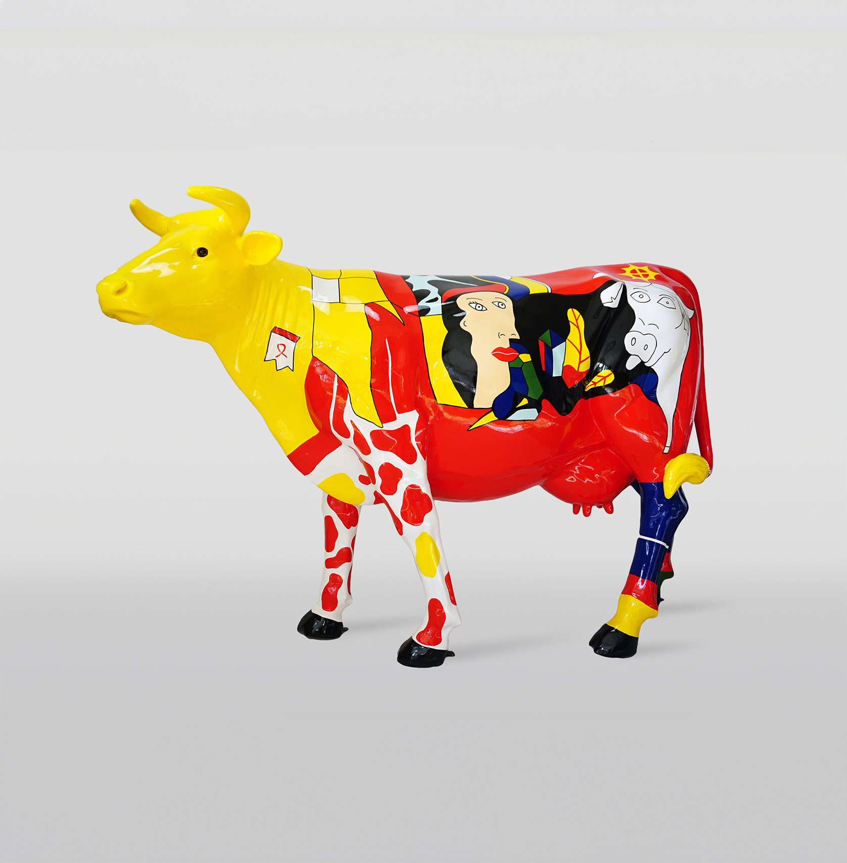 Cow with Picasso motif 1 Colorful, painted cow sculpture with a yellow head and abstract designs in red, yellow, black, and white.