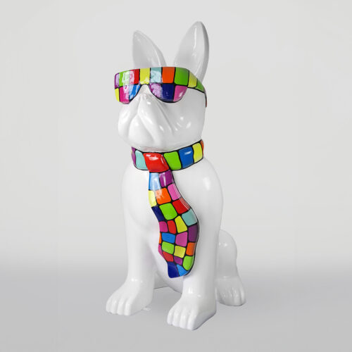 White dog statue wearing colorful sunglasses and a matching tie.