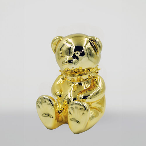 Golden bear sculpture with a spiked collar on a white background.