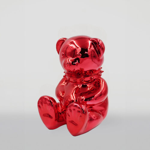 Red chrome teddy bear sculpture with a spiked collar, sitting upright against a plain background.