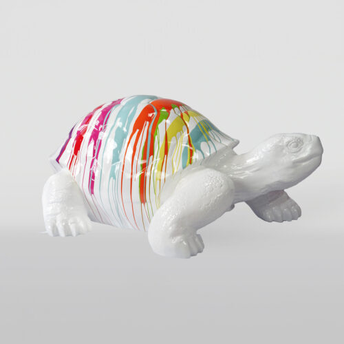 White turtle sculpture with a shell featuring multicolored paint drips.